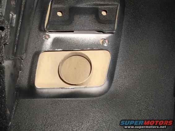 close-up of a car's interior panel with a circular cutout for a speaker