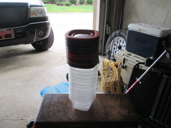 Black pickup truck front corner, Texas Raiders license plate, stacked containers