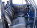 1964 Volkswagen Beetle - The interior of a blue vehicle features black racing seats, a roll cage, and a manual shifter.