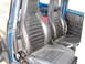 1964 Volkswagen Beetle - The interior of a car shows two black bucket seats and a roll cage, with a blue door panel visible.