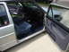 1985 Volkswagen GTI - The interior of a silver Volkswagen Golf shows blue fabric seats and door panels with the doors open.