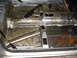 1985 Volkswagen GTI - The bare interior floor pan of a vehicle, showing the transmission tunnel and handbrake assembly.