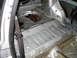 1985 Volkswagen GTI - The bare metal interior of a car's trunk, with a seatbelt visible.