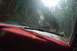 1983 Ford Bronco - Two SUVs navigate a wet, muddy path through a dense forest.