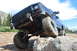 1983 Ford Bronco - This heavily modified truck is navigating a rocky trail in the mountains.