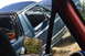 1983 Ford Bronco - View from inside a damaged teal pickup truck, with a reflection of trees in the side mirror.