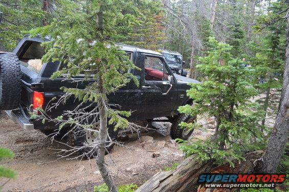 Black 1980s Ford Bronco navigating rocky terrain