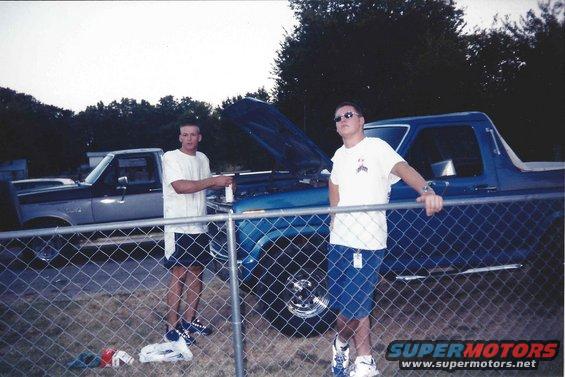 Blue 1982 Ford Bronco with hood open, two men standing nearby