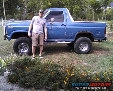 Blue 1982 Ford Bronco with a man standing beside it
