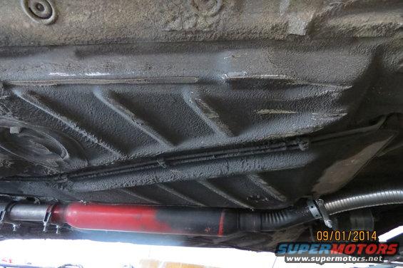 Underside of car with red muffler and exhaust pipe. Date stamp 09/01/2014