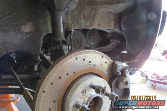 Car's front brake rotor and suspension components, viewed from below