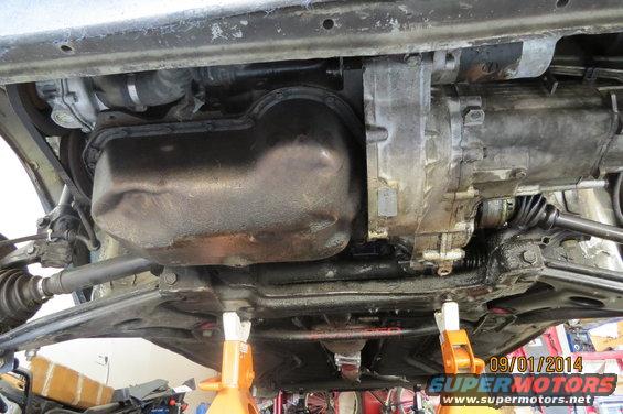 Underside view of a car's engine oil pan and transmission assembly, supported by jack stands. Date stamp reads 09/01/2014
