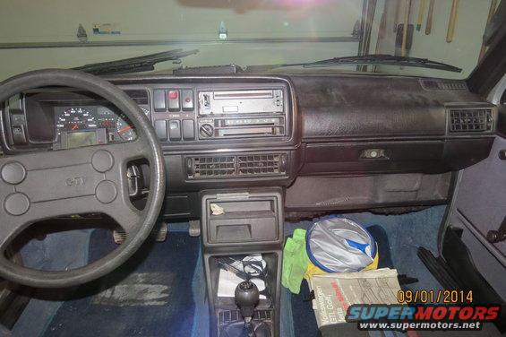 Dashboard and steering wheel of a 1985 Volkswagen GTI. Steering wheel has a GTI emblem
