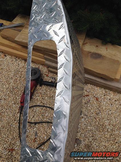 diamond plate metal piece with cutout, angle grinder nearby