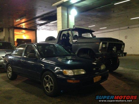 Dark pickup truck with a light bar on top, seen from a 3/4 front angle