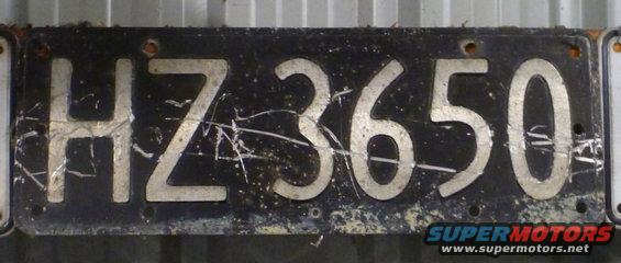 Black license plate with white characters HZ3650, scratched and worn
