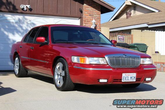 Red 2002 Mercury Grand Marquis parked in driveway, front 3/4 view