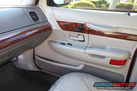 Interior door panel with wood trim and 'Grand Marquis' badge. 2002 Mercury Grand Marquis