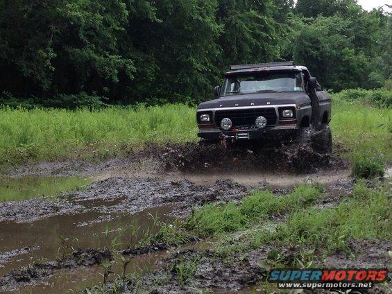 1979 Ford Bronco driving through mud, front view