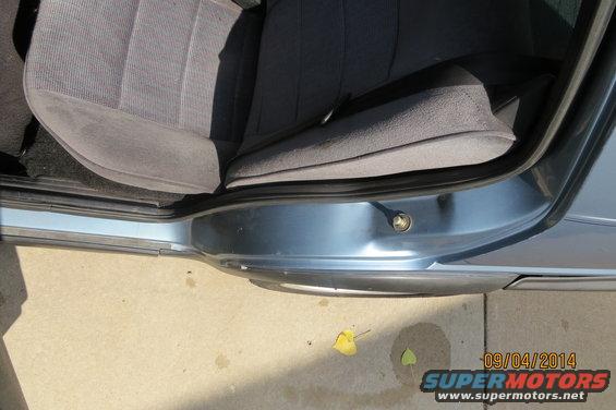 Interior shot of a car door sill and part of the seat. There's a date stamp and website URL in the corner