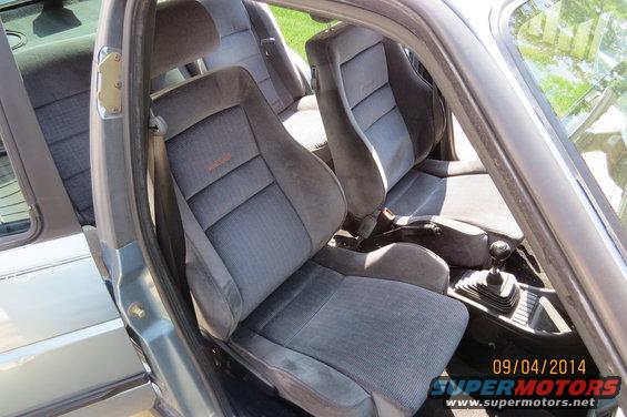 Interior view of a 1990 Volkswagen Jetta showing grey seats and manual transmission