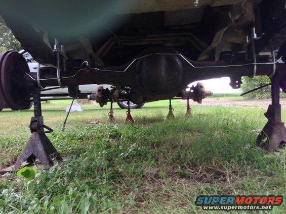 Rear axle assembly on jack stands, showing differential and brake drums