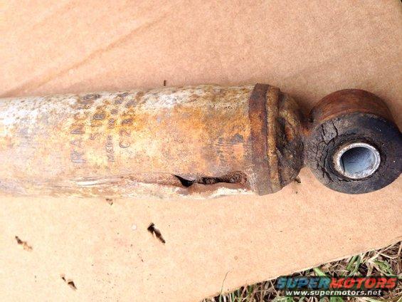 Rusted shock absorber with visible text 'FRANCO 516B' and 'MADE IN USA C23'