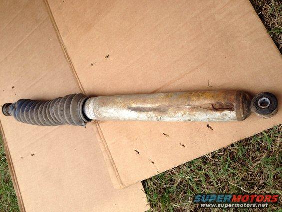 Shock absorber with blue bellows and rusted metal body