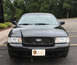 2009 Ford Crown Victoria - A black 2009 Ford Crown Victoria police car is shown from the front, displaying a "State Patrol" license plate.