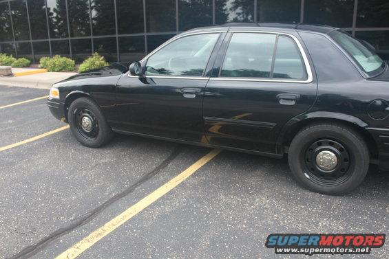 Black 2009 Ford Crown Victoria parked on asphalt with yellow lines