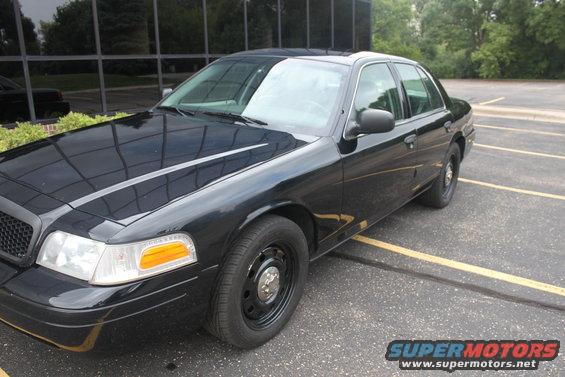 Black 2009 Ford Crown Victoria sedan parked in a lot, front 3/4 view