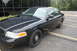 2009 Ford Crown Victoria - This black 2009 Ford Crown Victoria sedan is viewed from the front three-quarter angle in a parking lot.