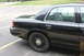 2009 Ford Crown Victoria - This black sedan is parked in a lot, with a view of its rear passenger side and interior.