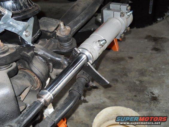 Power steering cylinder mounted to suspension components