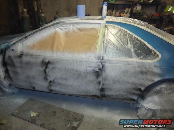 Car door and side panel covered in masking paper and primer spray