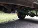 1971 Ford F-250 - The underside of a truck is visible, including the rear axle and a green exhaust pipe.