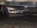 1988 Ford Bronco - Chrome exhaust tip with engraved lettering, attached to a vehicle's exhaust system.