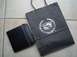 2004 Cadillac CTS - Cadillac shopping bag and wallet with embossed logos sit on a tiled floor.