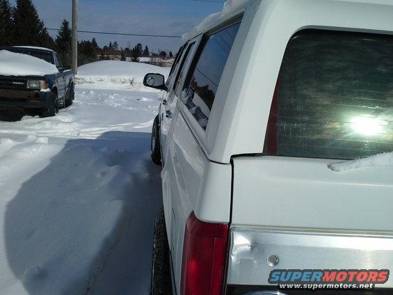 1996 Ford Bronco parked in snow, side view. Another truck is visible to the left