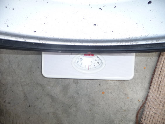 Close-up of a tire resting on a white bathroom scale