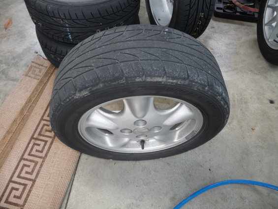 Tire and silver alloy wheel with five spokes, viewed from the front