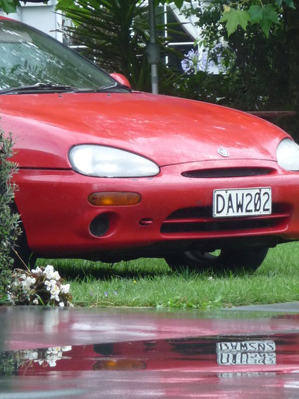 Red 1993 Mazda MX-3 front view with license plate DAW202