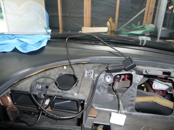 Car dashboard with wires and vents exposed, blue cloth on dash