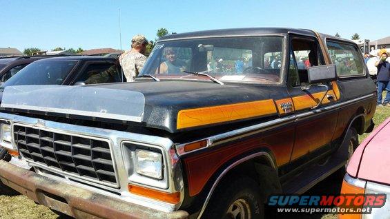 Black 1978 Ford Bronco with orange and red stripe accents, seen from a 3/4 front angle