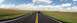 2007 Ford Crown Victoria - A police car is stopped on a highway in a scenic landscape with badlands in the background.