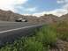 2007 Ford Crown Victoria - A two-tone police car sits on the shoulder of a highway with hills in the background.