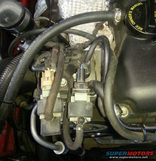 Close-up of engine parts with hoses and electrical connectors