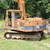 Excavator with tracks and boom, outdoors