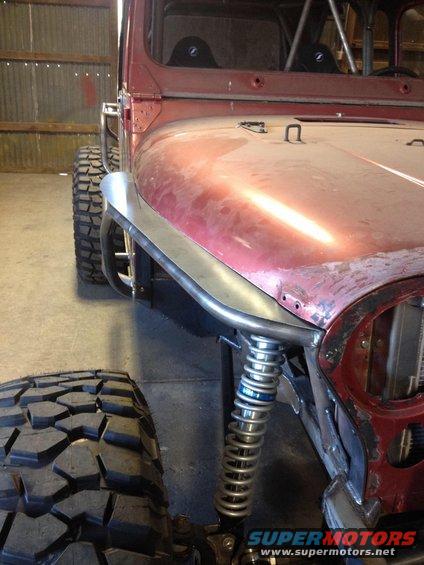 1985 Jeep CJ7 front fender, large off-road tire, and suspension components visible