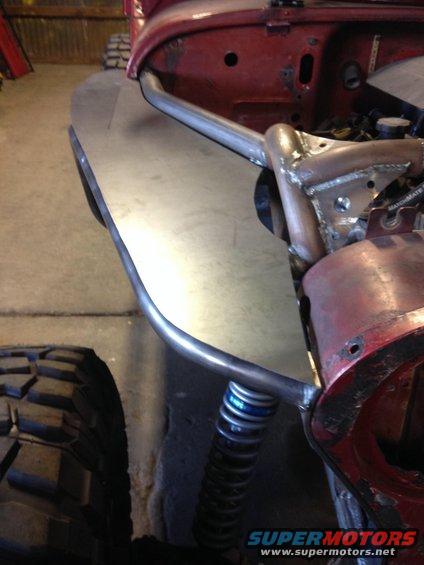 Red Jeep CJ7 front fender with custom metalwork and suspension components visible